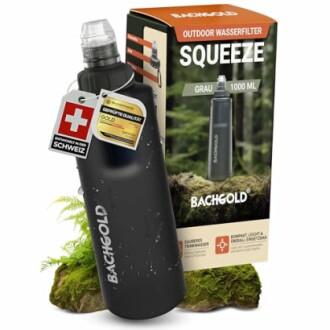 Schwarze Wasserfilterflasche mit Verpackung auf Moos