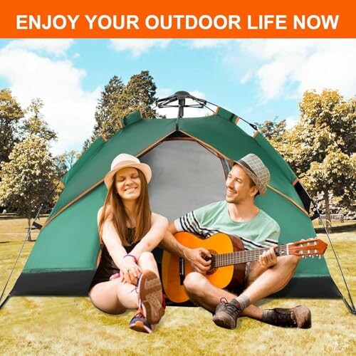 Paar sitzt vor einem Zelt im Freien, Mann spielt Gitarre.