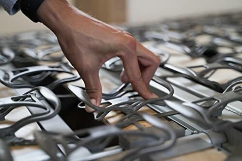 Hand stellt Bettlatten ein.