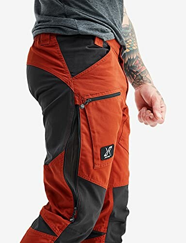 Person trägt orange-schwarze Outdoor-Hose