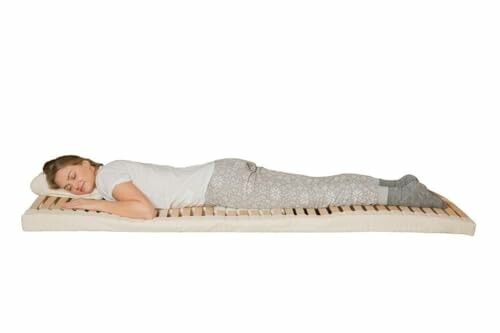 Frau schläft auf einer Holzlattenmatratze.